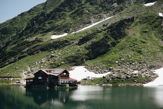 ルーマニアのバレア湖と雪に覆われたピークを持つ夏のフグラシ山の風景を見る