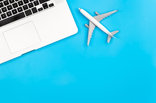 Миниатюра ноутбука и самолета на синем фоне плоской планировки копировального пространства