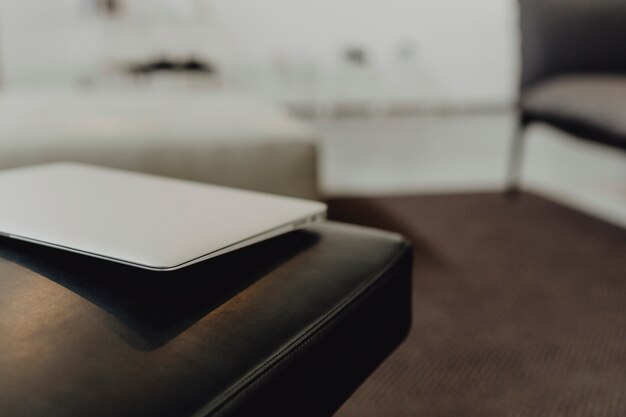 A laptop on a black leather sofa