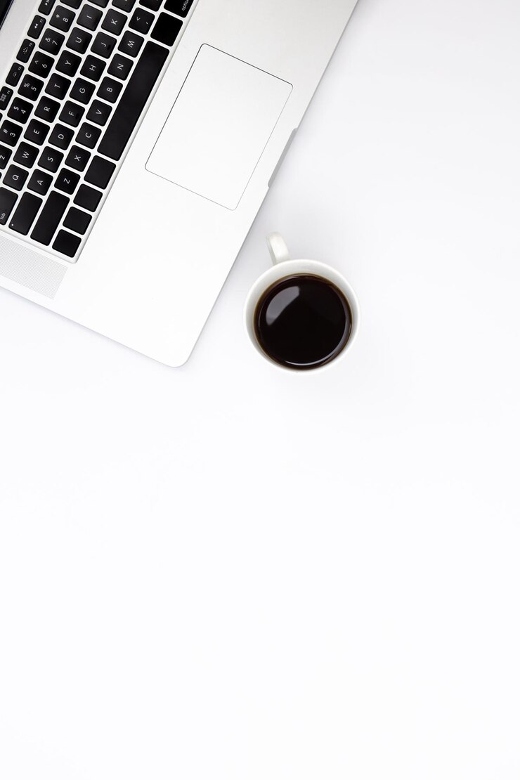 Laptop and a cup of black coffee on a white background top view