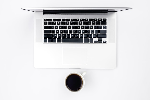 Free photo laptop and a cup of black coffee on a white background top view