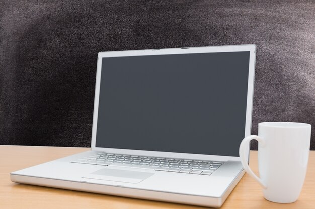 Laptop and cup with blackboard