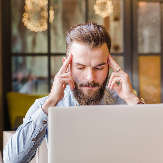 Laptop in front of stressed young man