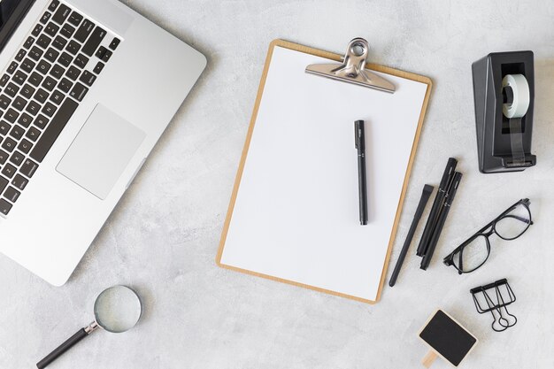 Laptop near eyeglasses and stationery 