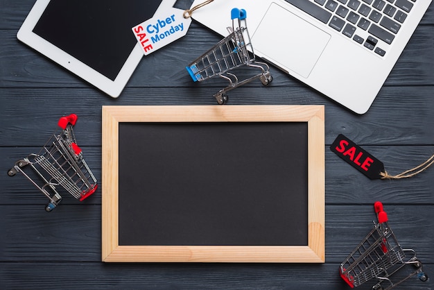 Laptop near tag, tablet, supermarket cart and photo frame