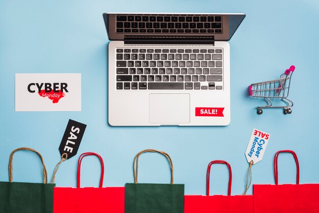 Laptop near tags, shopping trolley and packets