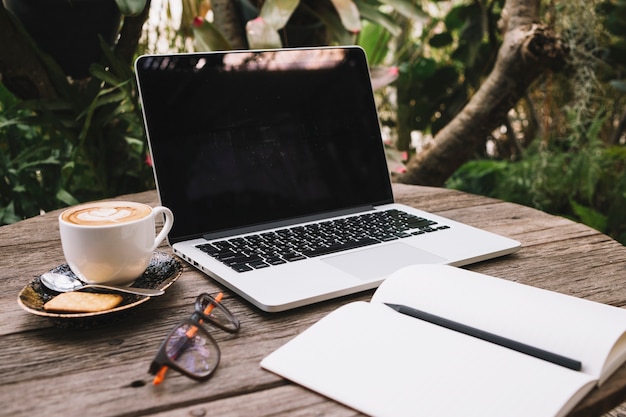 Laptop and notebook on timber table