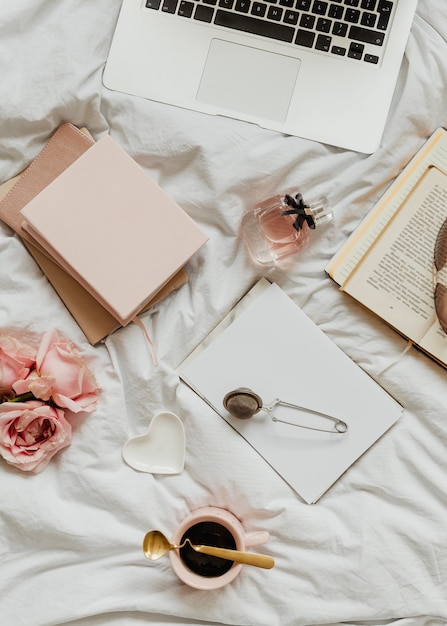 Laptop and notebooks on a girls bed