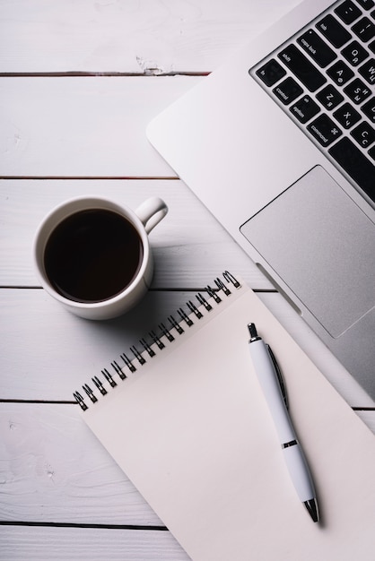 Laptop and notepad composition on desk