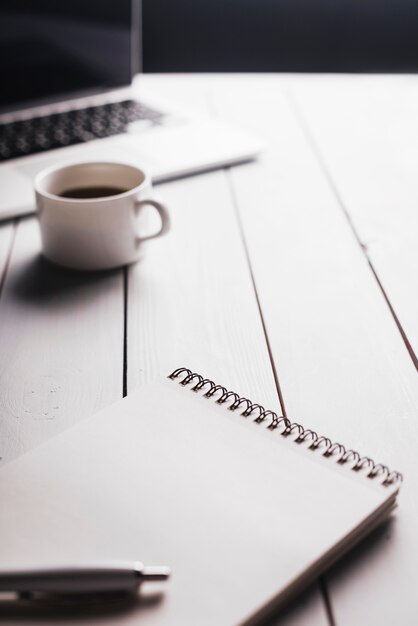 Laptop and notepad composition on desk