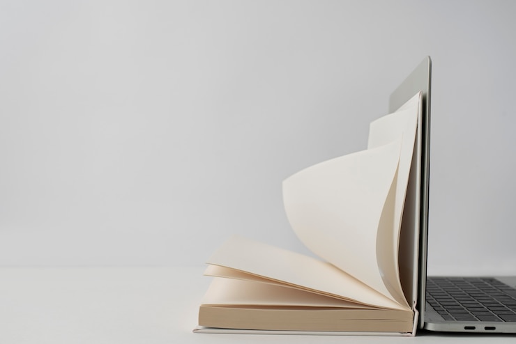 Free Photo laptop and open book arrangement