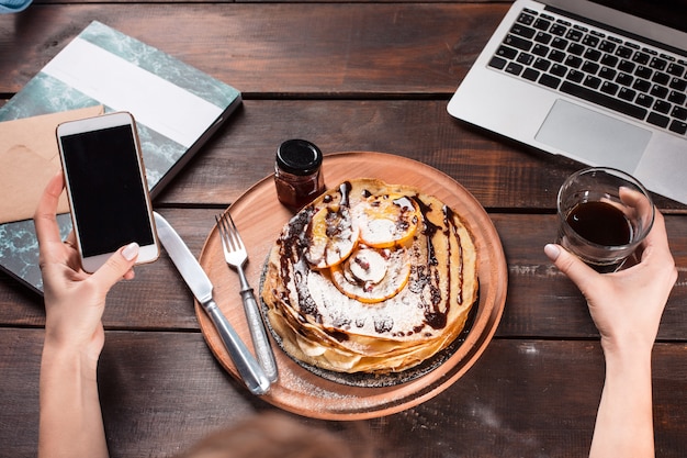 Foto gratuita laptop e frittelle con succo. colazione salutare