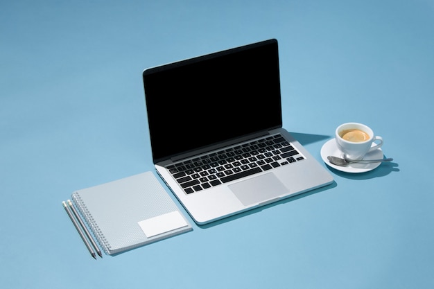 The laptop, pens, phone, note with blank screen on table