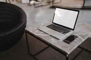 Free photo laptop and a phone on a marble table