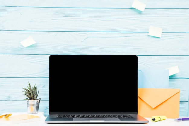 Laptop and post it notes on light blue background