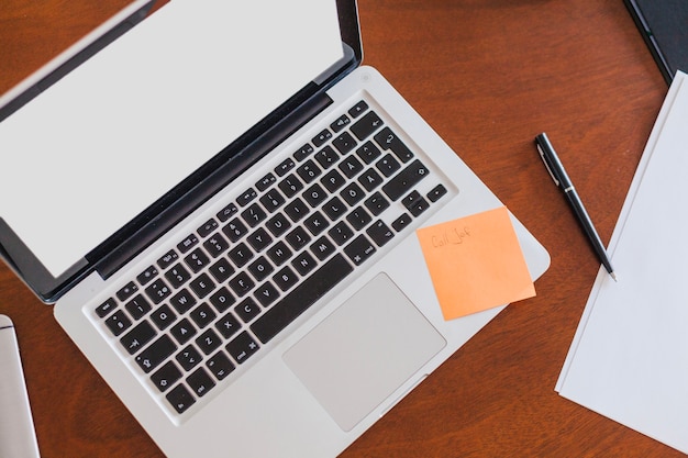 Free photo laptop sheets and pen placed on table