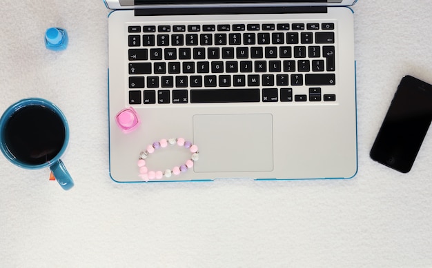 Laptop, smartphone, mug and nail polish