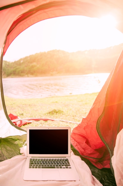 Laptop standing in tent outdoors