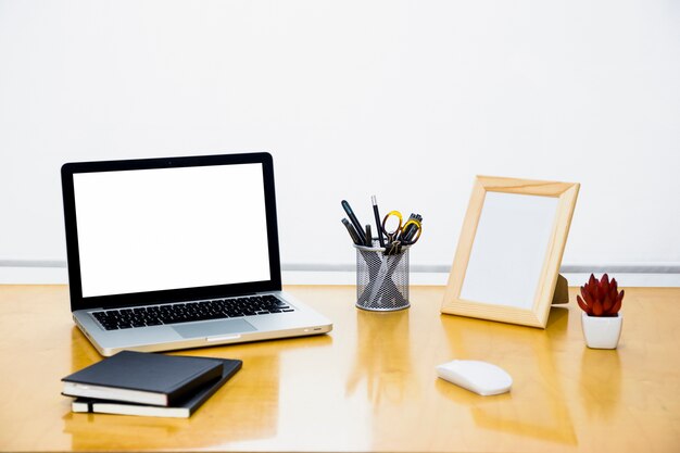 Laptop with blank frame on wooden table