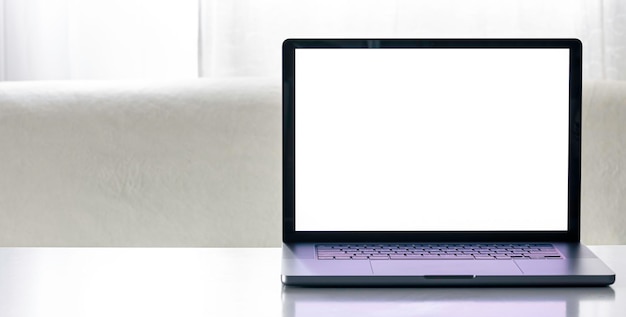 Free photo laptop with a blank white screen on a blurred light background