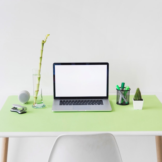 Laptop with blank white screen on office desk