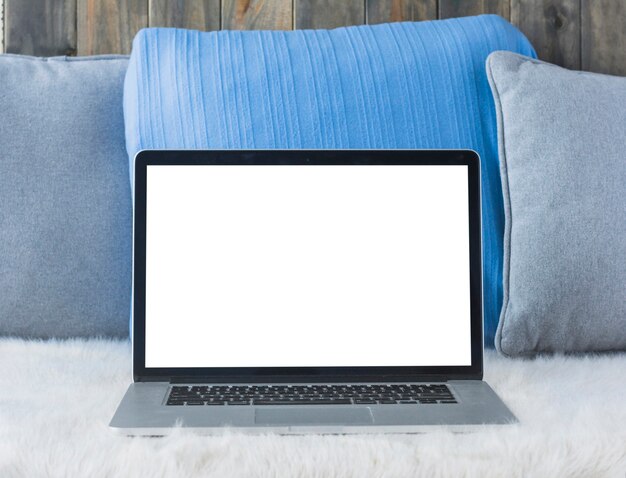 Laptop with blank white screen on sofa