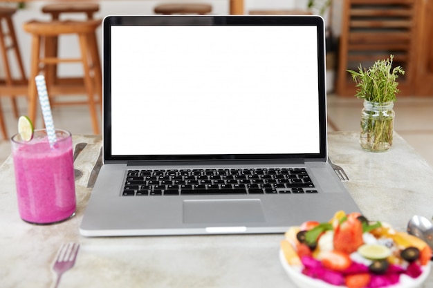 Laptop with blank white screen on table