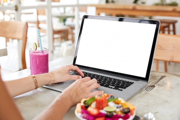 Laptop with blank white screen on table