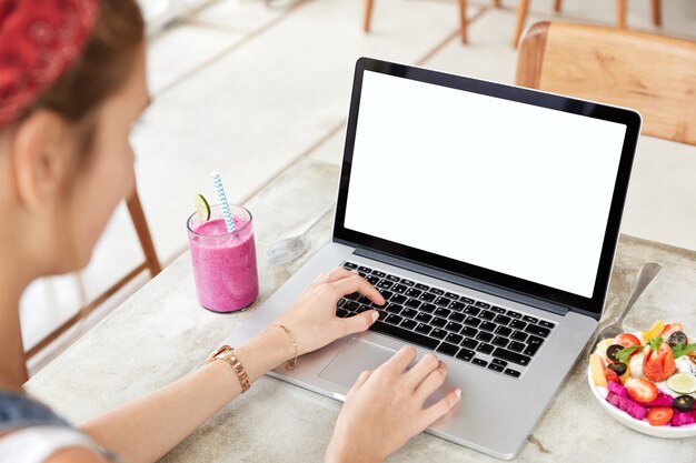 Laptop with blank white screen on table