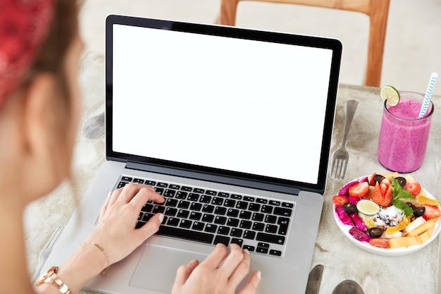 Laptop with blank white screen on table