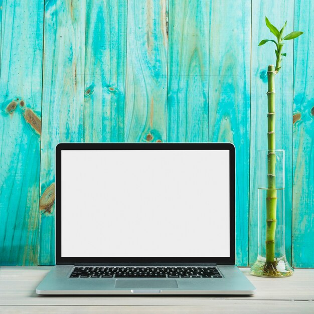 Laptop with blank white screen on wooden desk