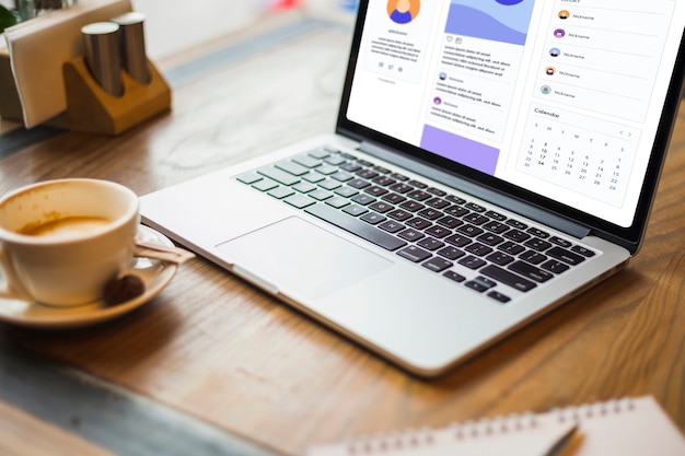 Laptop with coffee cup on table