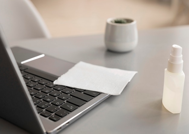 Free photo laptop with disinfectant at the office