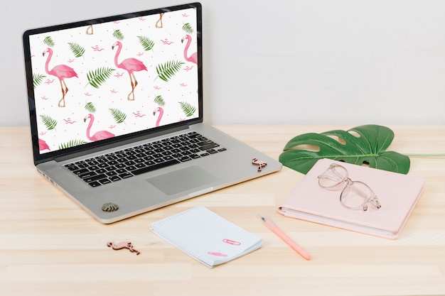 Laptop with flamingos on screen on table
