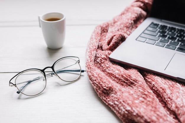 Laptop with glasses on table 