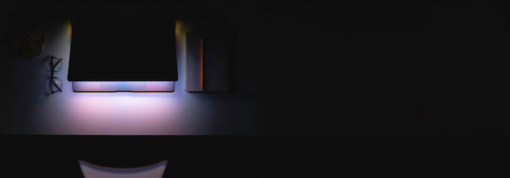 Free Photo laptop with a glowing screen on a table in the dark top view copy space