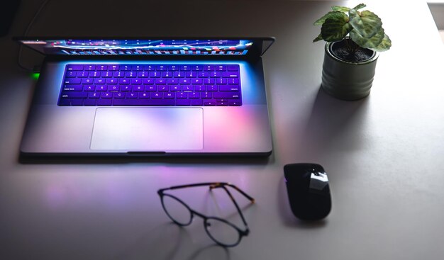 Laptop with graphs and statistics and glasses on the table