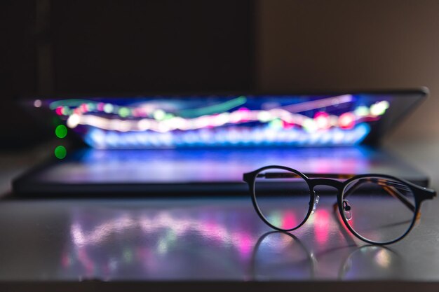 Laptop with graphs and statistics and glasses on the table