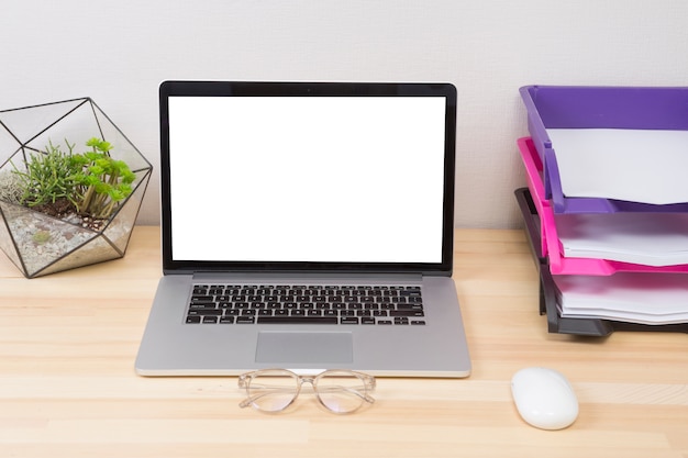 Free photo laptop with green plant and mouse on table