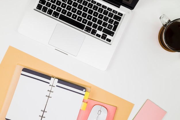 Laptop with notebook and coffee cup