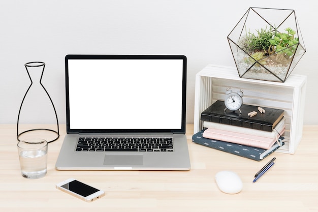 Laptop with notebooks on light wooden table