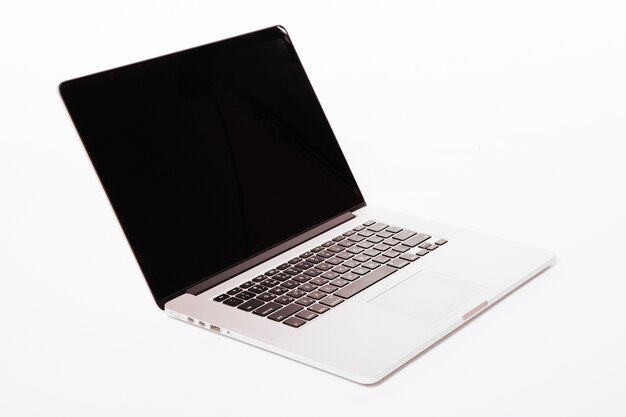 白い画面のノートパソコン。白い壁に隔離