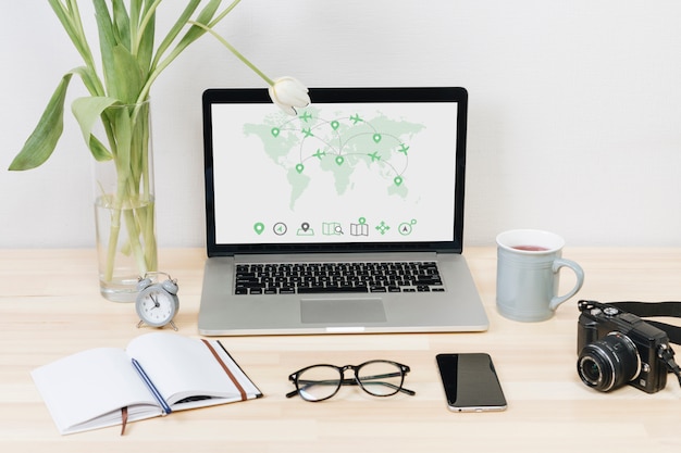 Laptop with world map on screen on table