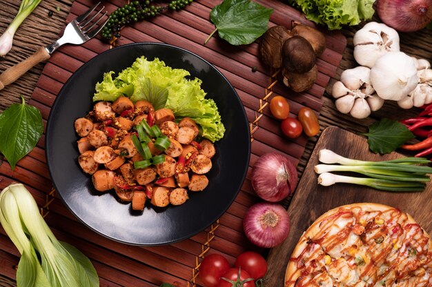 Larb Sausage with Chili Spring onions and lettuce in a black plate