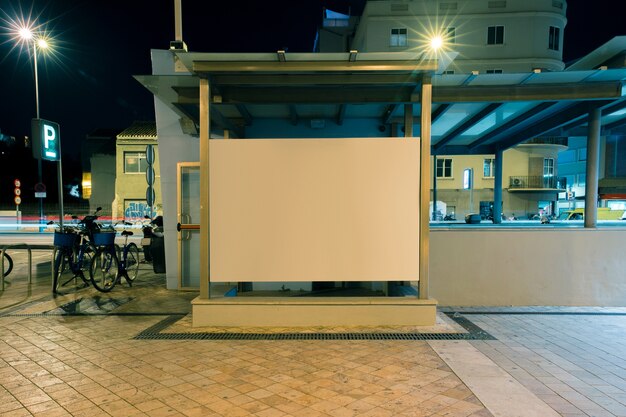 Large blank billboard on a street wall at night