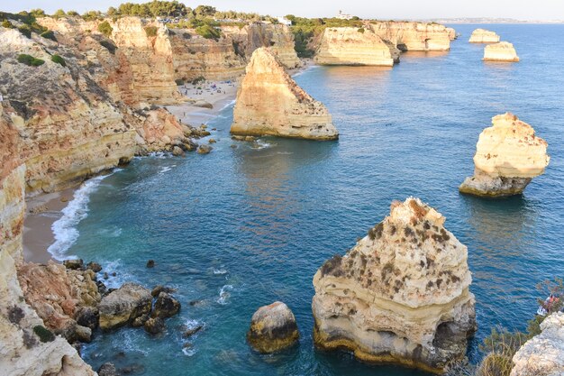 Large cliffs sticking out of the water during daytime