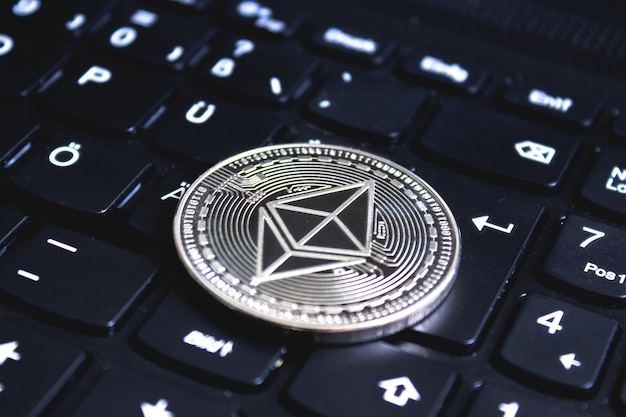 Large coin placed on top of a black computer keyboard