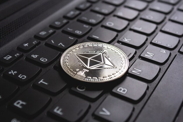 Large coin placed on top of a black computer keyboard