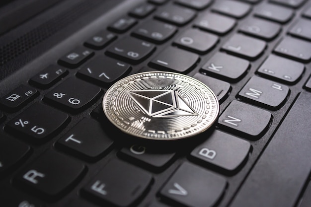 Large coin placed on top of a black computer keyboard