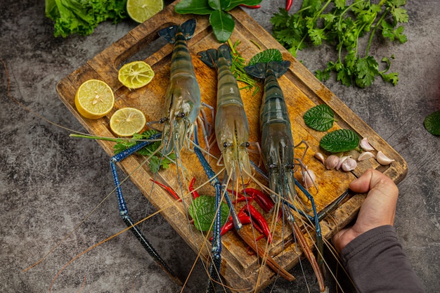 Free photo large fresh river prawns ready to cook decorated with beautiful side dishes.